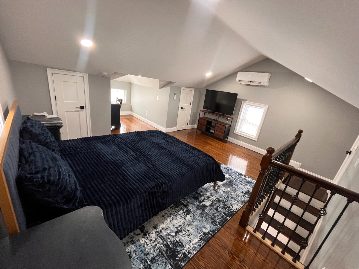 Spacious king bedroom with modern shared living spaces in Queens Village - Photo 1